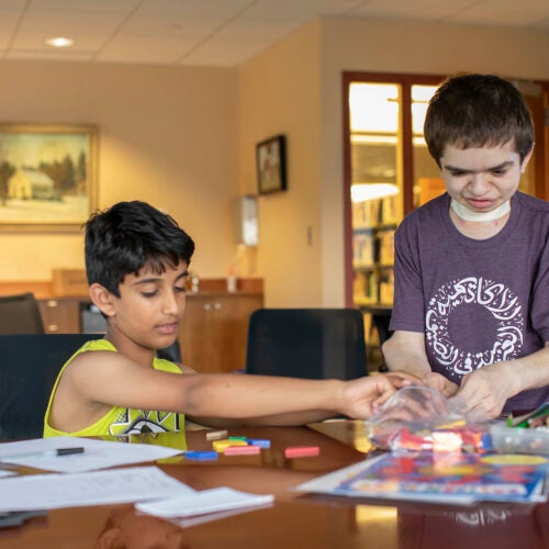 Ben Elwy works with an elementary school student at the library