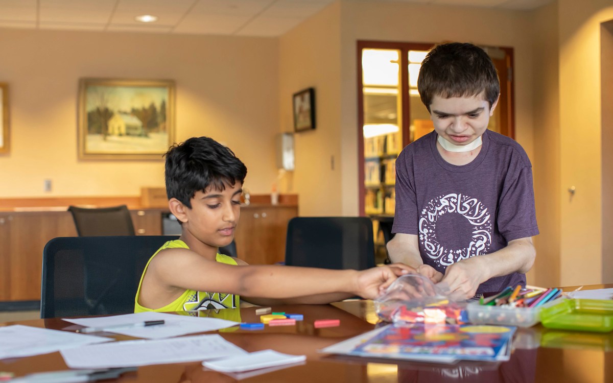 Ben Elwy works with an elementary school student at the library