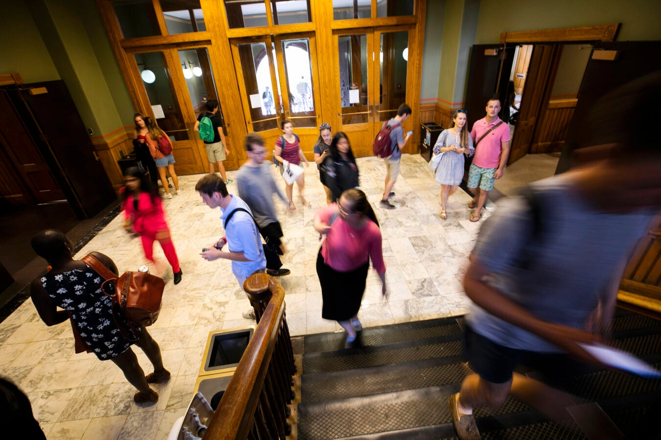 Students walk around the entrance to Sever Hall.