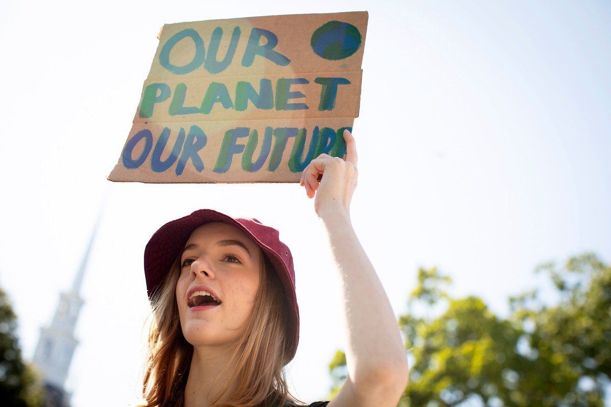 Harvard Strike for Climate Justice takes place on Harvard Science Center Plaza. Lily Hall '21 raises a sign during the rally. 