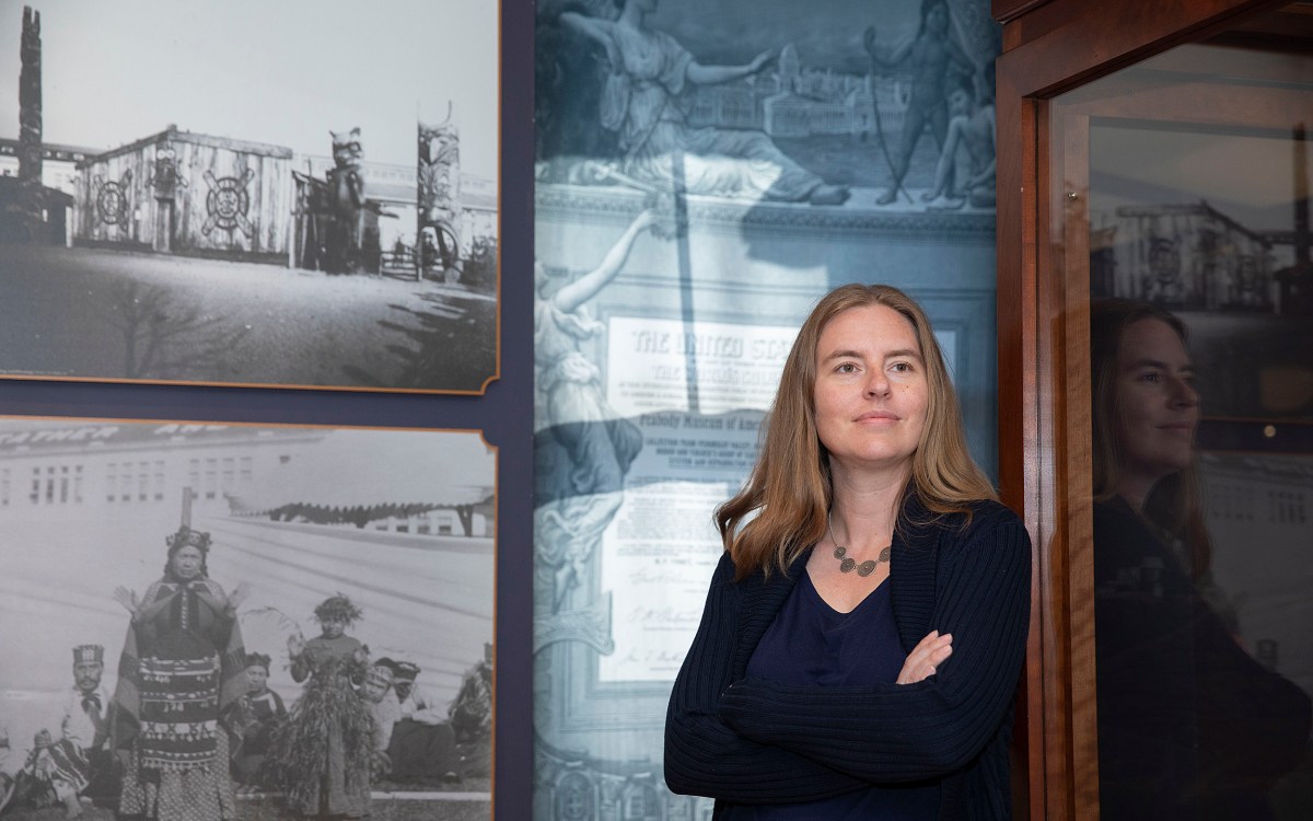 Christina Warinner is a new faculty member photographed in front of a display at the Peabody Museum.
