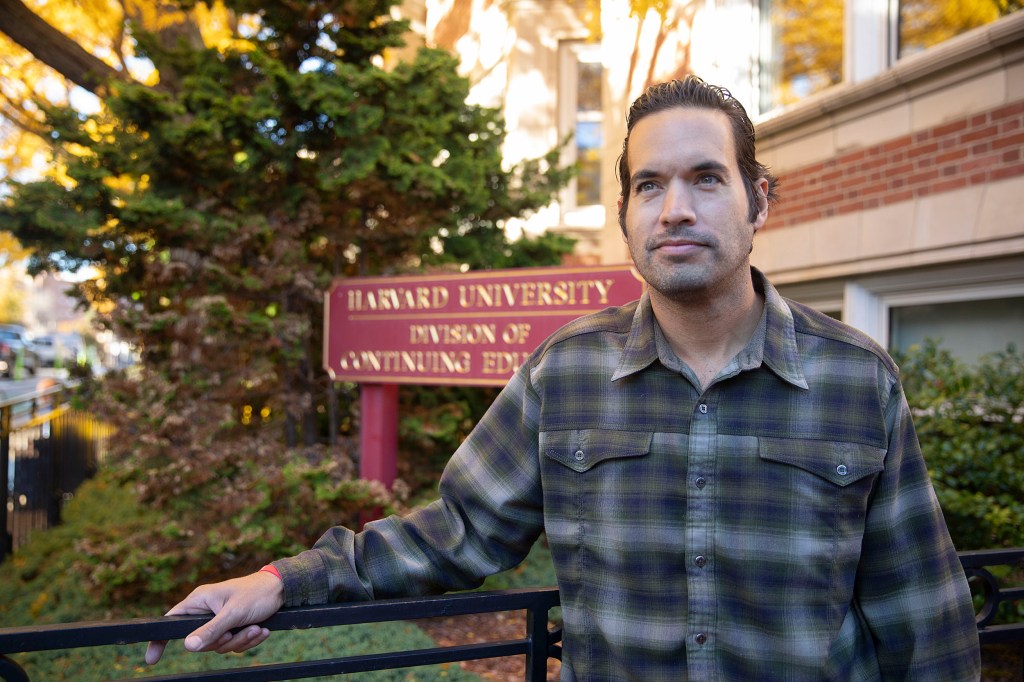 Student standing in front of Extension School sign