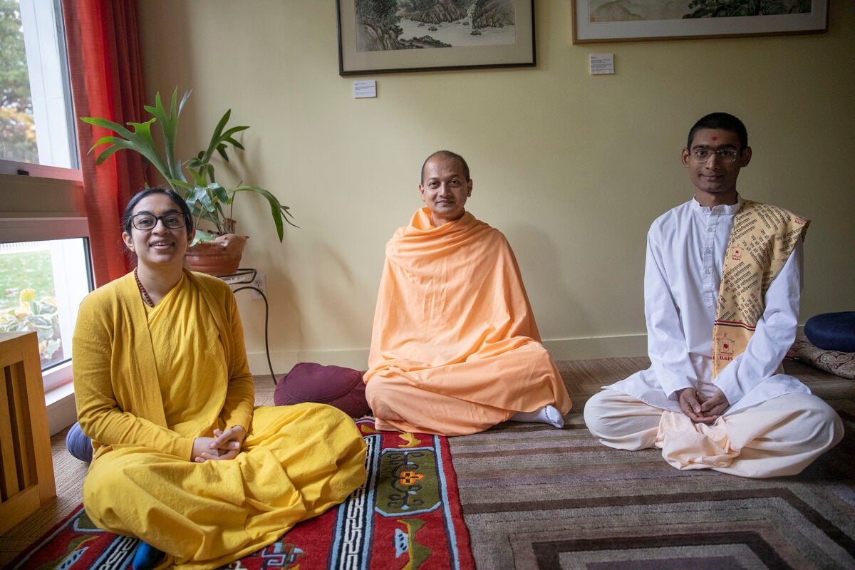 Three Hindu monastics at Harvard Divinity School, all seated.