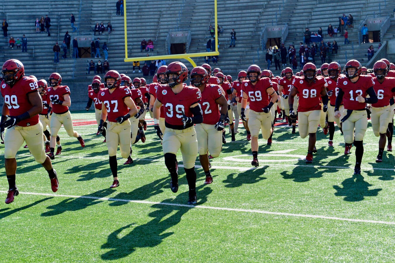 The Harvard football team takes the field against Dartmouth.
