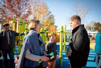 Marty Walsh talks to Katie Lapp and a child on a playground