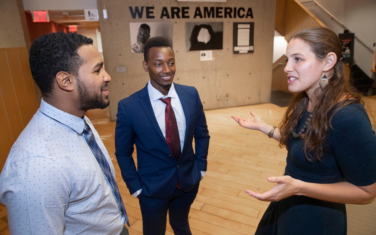 Teacher Jessica Lander with students Ezequiel Nunez and Robert Aliganyira in the 'We Are America' photo exhibit at Gutman Library.