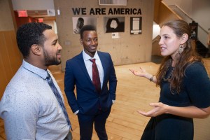 Teacher Jessica Lander with students Ezequiel Nunez and Robert Aliganyira in the 'We Are America' photo exhibit at Gutman Library.