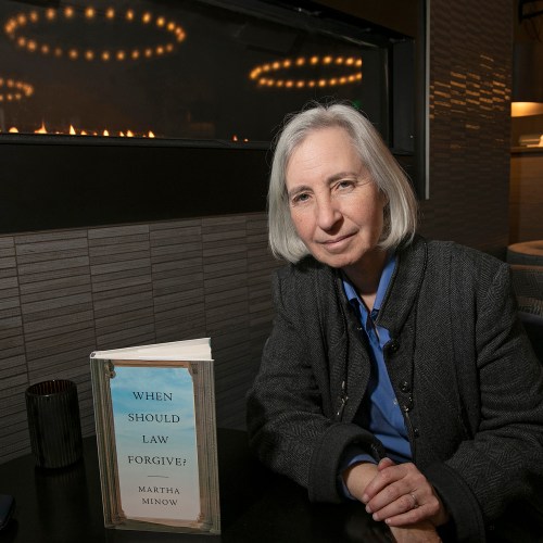Professor Martha Minnow sitting at a table with her book in front of her.