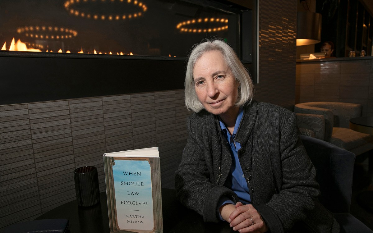 Professor Martha Minnow sitting at a table with her book in front of her.