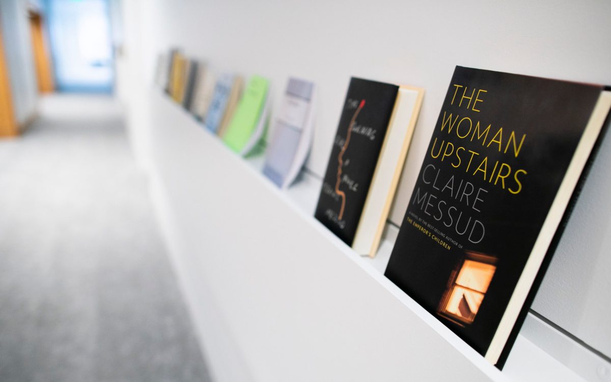 A row of books lines a shelf in the Department of English's creative writing program in Lamont Library.