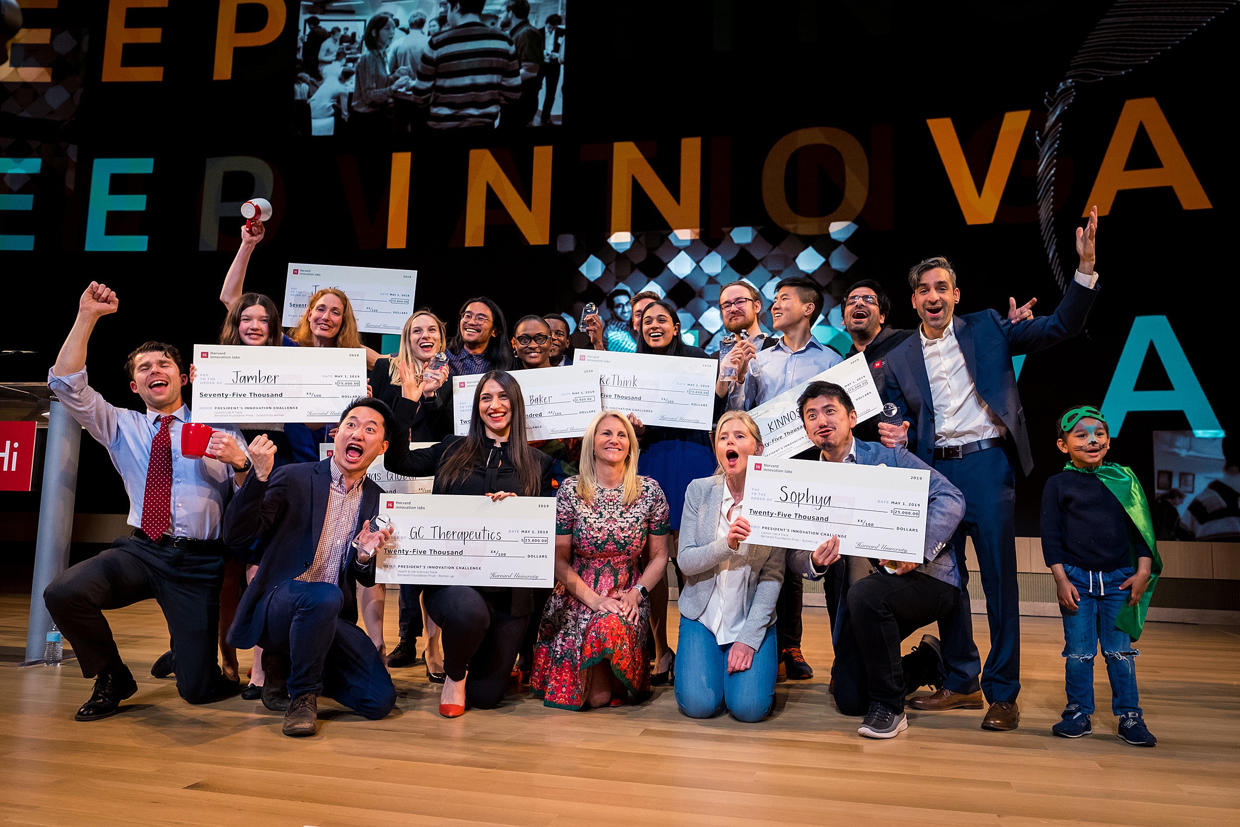 Innovation Challenge awardees celebrate onstage with their prize money checks.