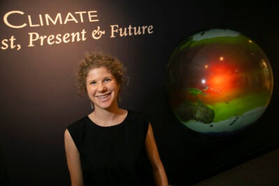 Tamara Pico in front of an image of the Earth.