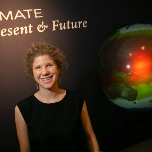 Tamara Pico in front of an image of the Earth.