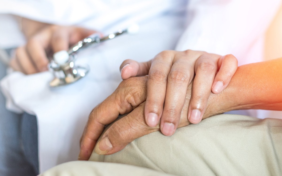 Doctor holding hand of patient.