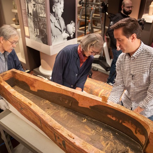 Dennis Piechota (left), Jane Drake, and Adam Aja view the inside of the coffin of Ankh-khonsu.