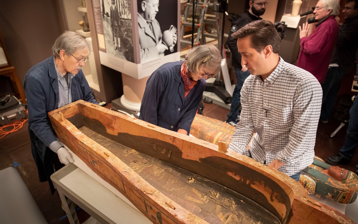 Dennis Piechota (left), Jane Drake, and Adam Aja view the inside of the coffin of Ankh-khonsu.
