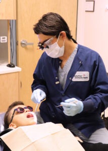 Dentist with a young boy getting a filling.