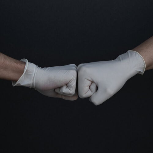 Fist bump wearing gloves.