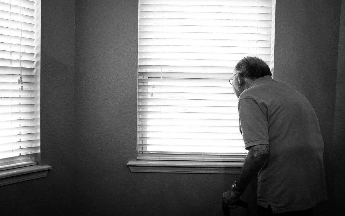 Older man looking out of window.