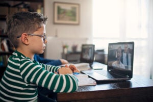 Little boys attending to online class from home.