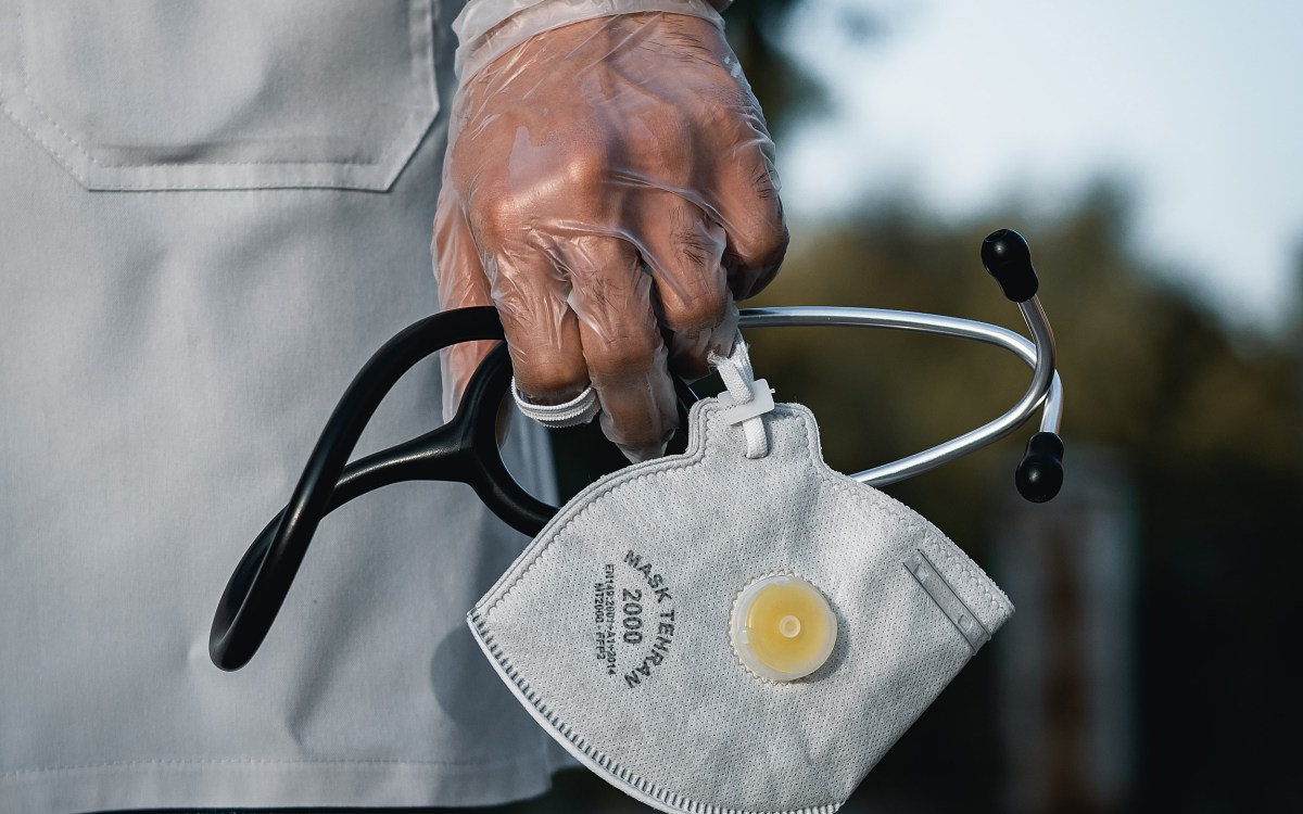 Person holding stethoscope and mask.