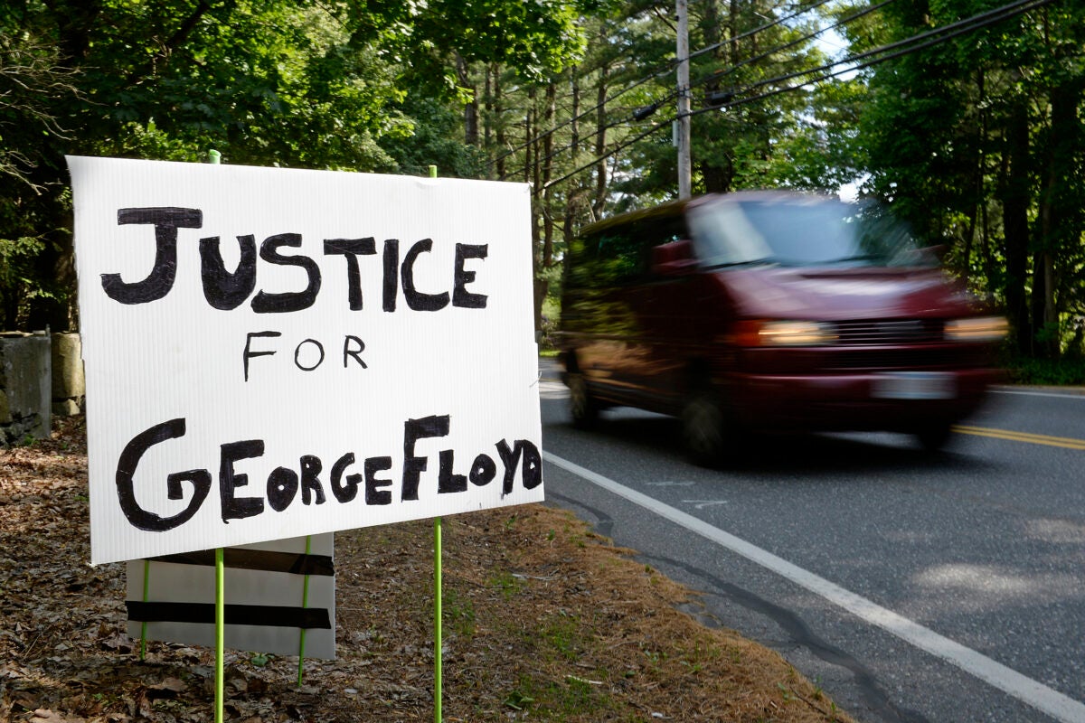 A sign reads, Justice for George Floyd.