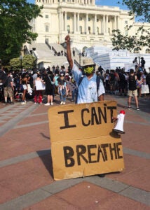 Glenn Foster holds up a sign saying "I can't breathe" in front of the Capitol.