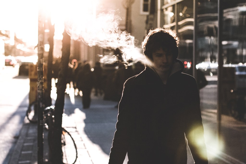 Person exhaling smoke from e-cigarette.