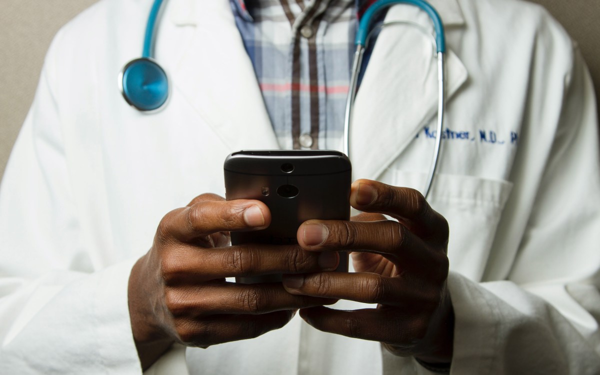 Doctor holding smartphone.