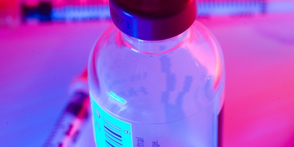 Syringe in vaccine bottle.