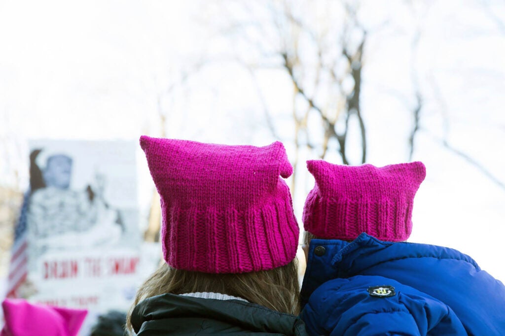 Adult and child wearing pink hats at Women's March in Boston.