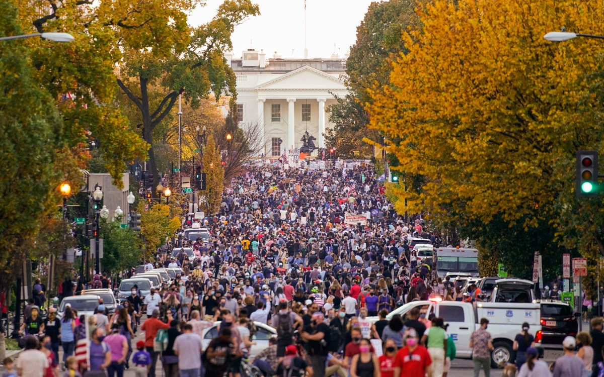 People gather along 16th street in front of the White House.