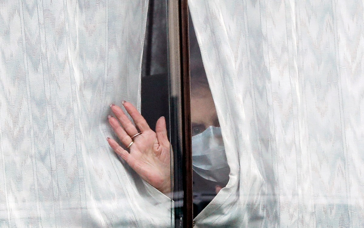 A woman waves from a window.