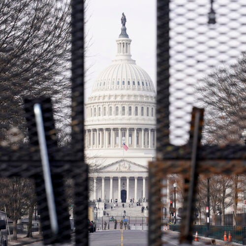 Capitol viewed through barricades.
