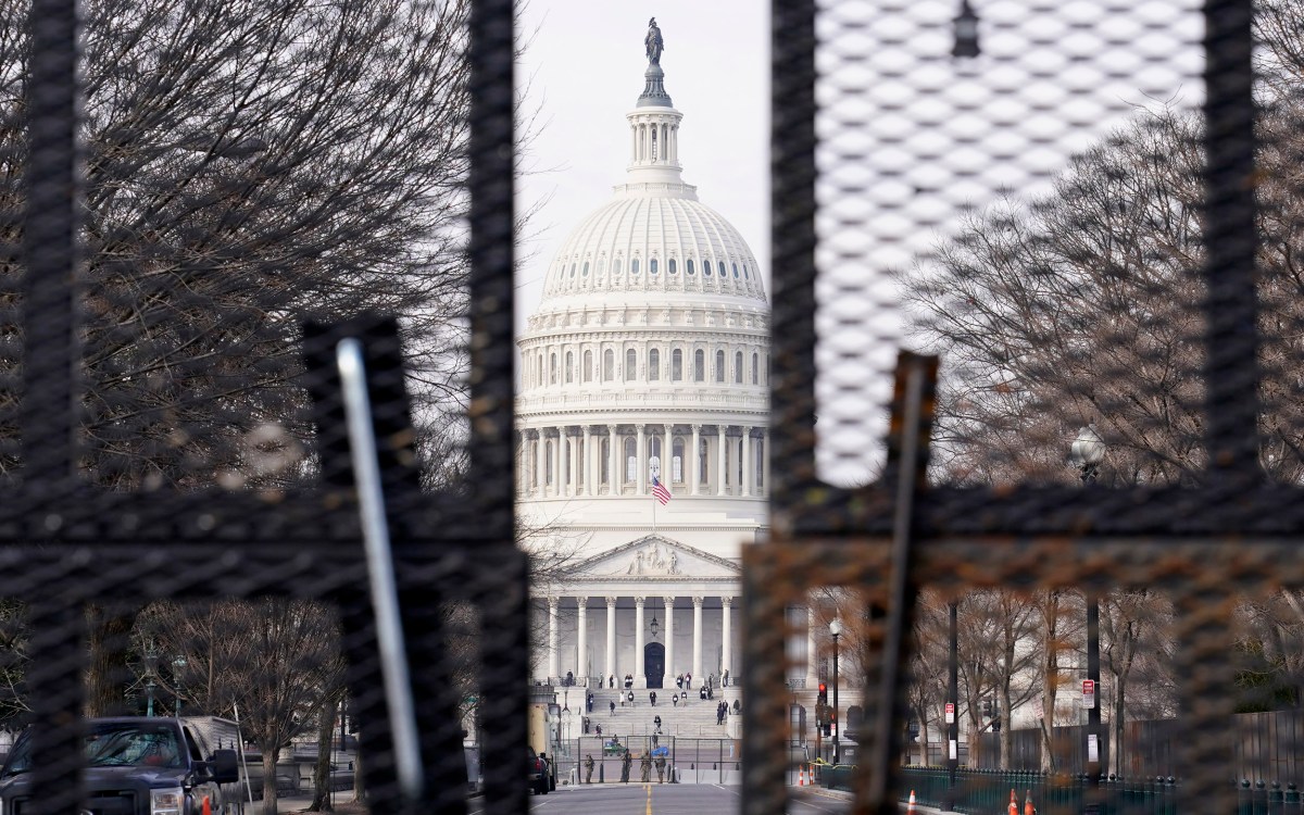 Capitol viewed through barricades.