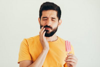 Man with sensitive teeth eating ice cream.