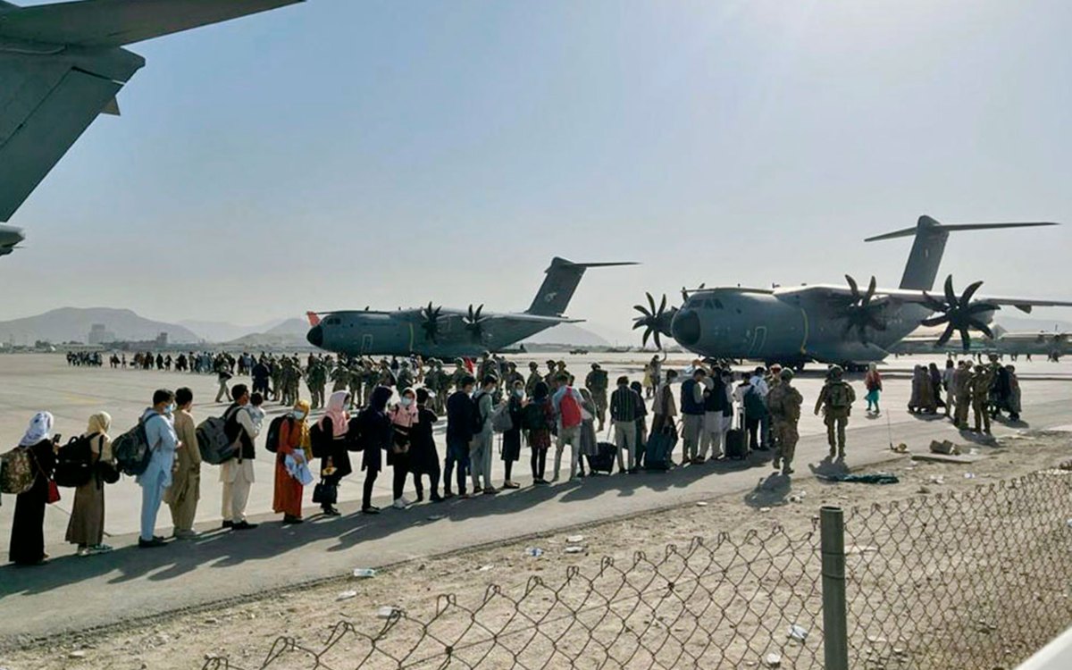 Afghan people wait at Kabul's airport.