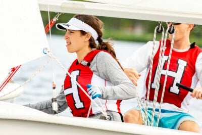 Harvard sailing team members Katie Barkin and Paul Kuechler, both ’22, navigate a drill on the Charles.