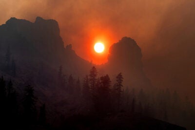 Caldor Fire creates smoky orange sky above Sierra Nevada mountains.