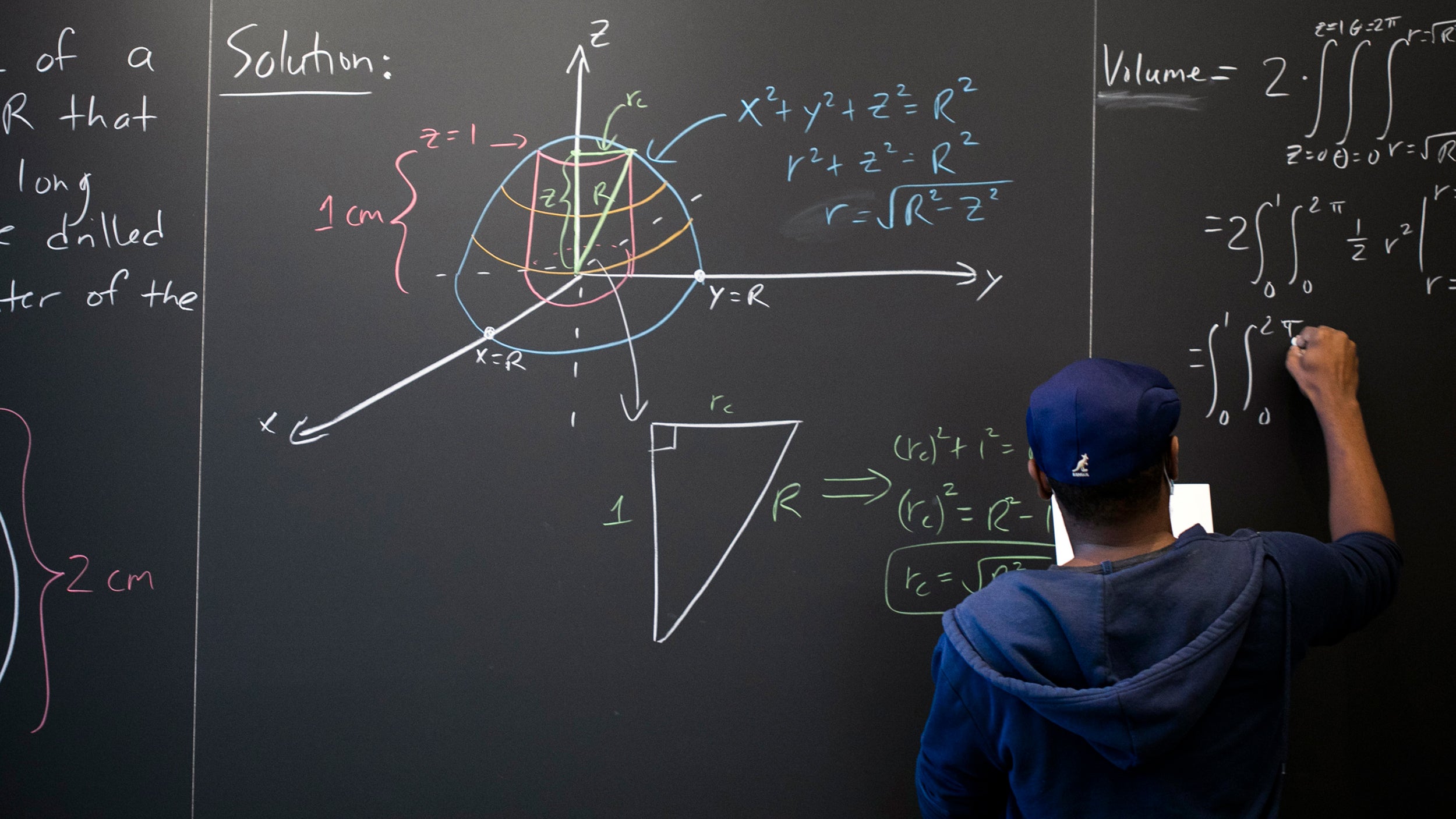 Hakim Walker writes on math lounge chalkboard.