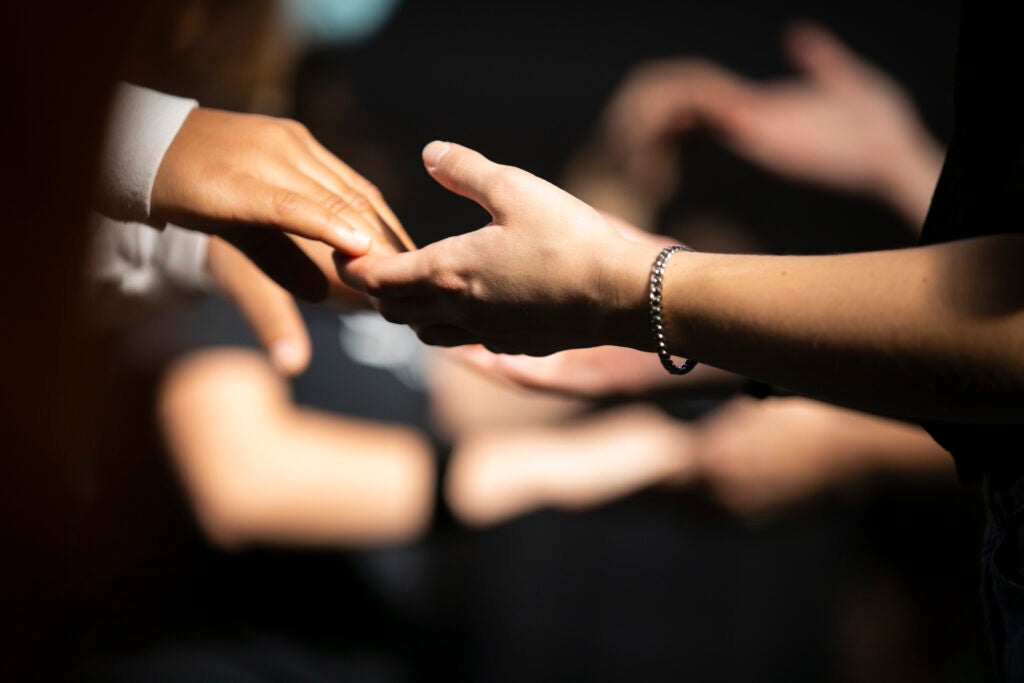 A detail of hands connecting during dance.