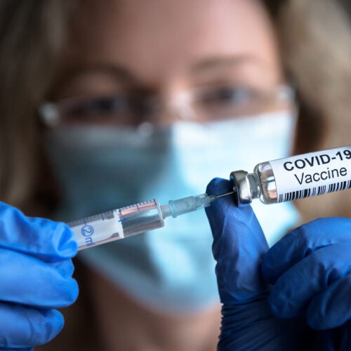Nurse holding COVID vaccine.