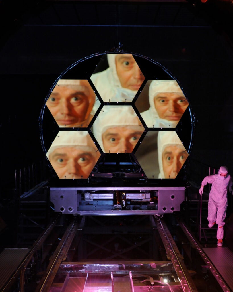 Jake Lewis is reflected in one of the mirrors on a James Webb Space Telescope Array.