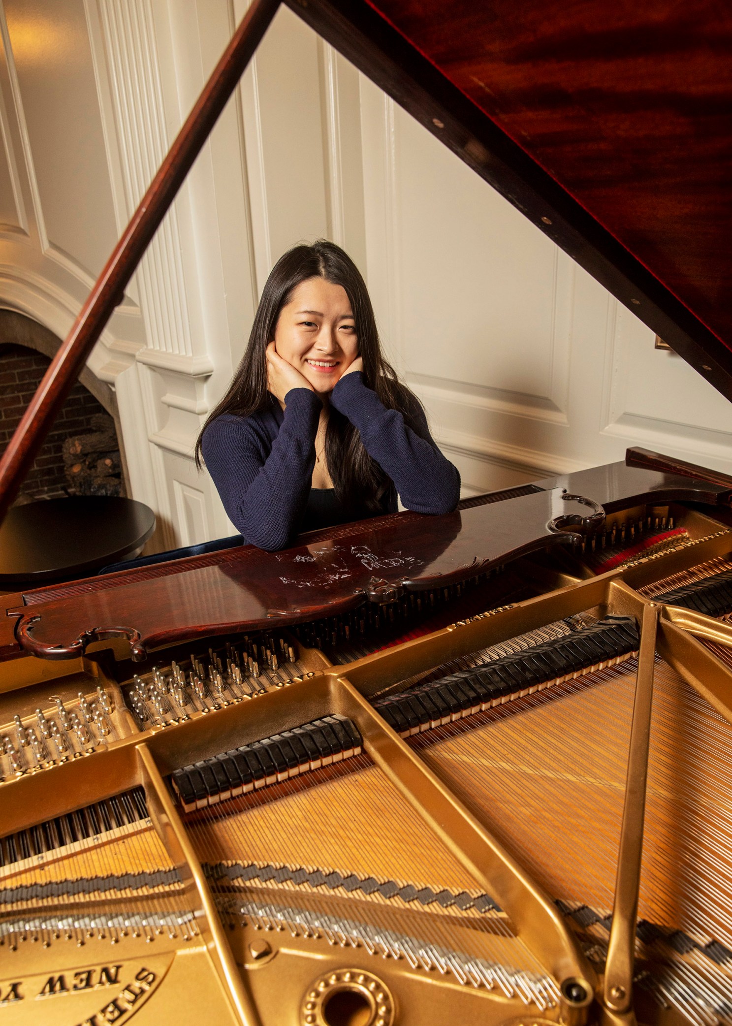 Julia Riew sits at piano.