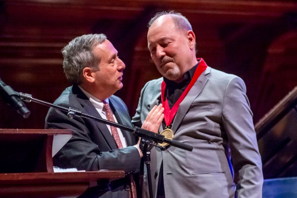 President Larry Bacow gives Ruben Blades a medal.