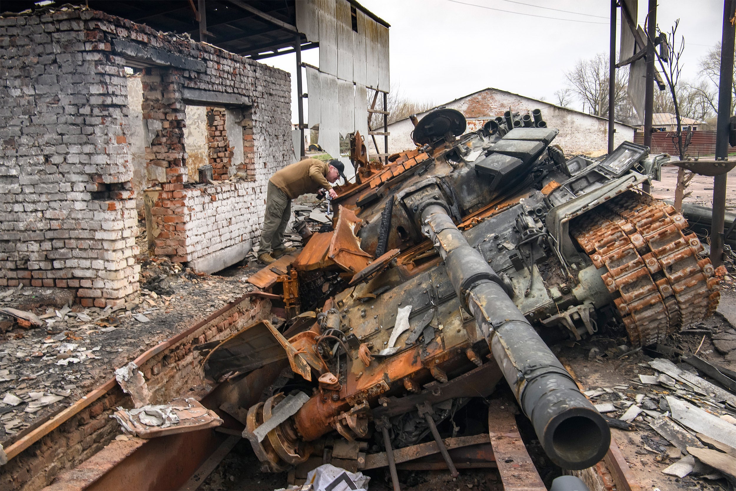 A man looks at Russian T-72 tank destroyed.