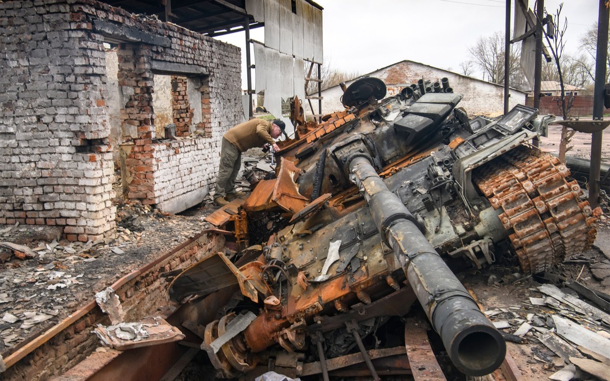A man looks at Russian T-72 tank destroyed.