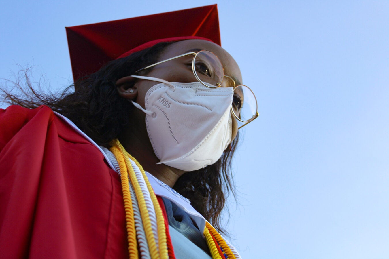 Sheila Onyango in graduation cap and gown and face mask.