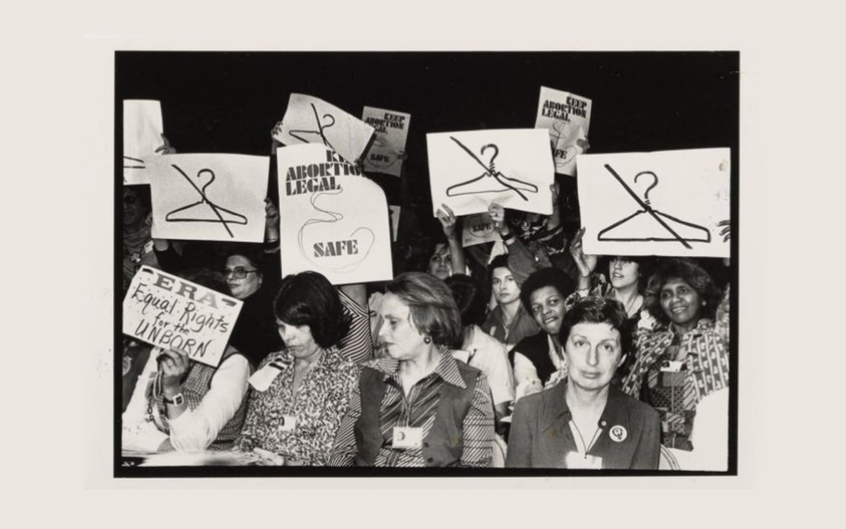 Women hold signs at International Women's Year conference in 1977.
