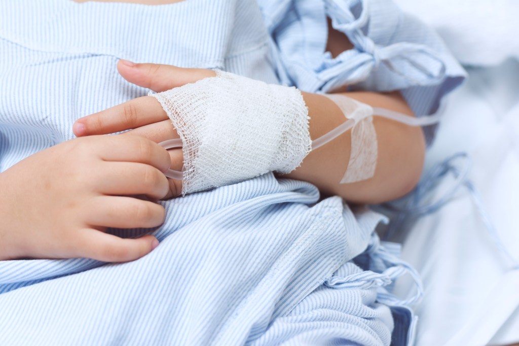 Hand of the sick child with saline solution